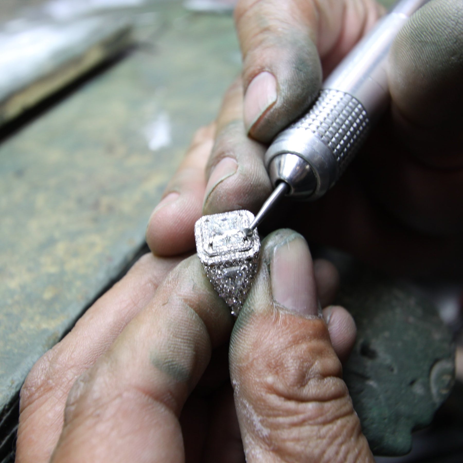 jewelers hands setting a diamond into a double halo setting at Shapiro Diamonds in Dallas