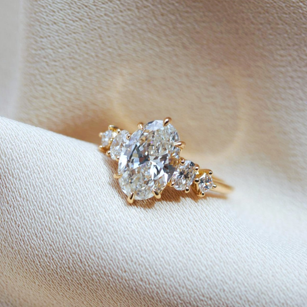 Oval cut diamond ring with graduated princess cut diamonds in yellow gold — Shapiro Diamonds Dallas