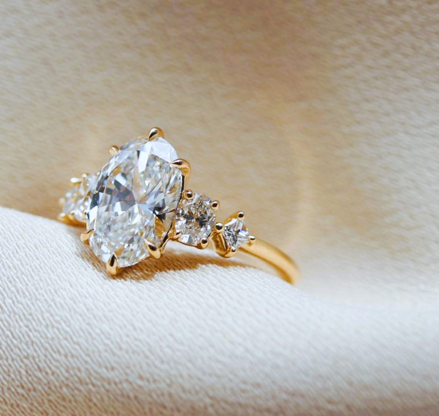 Oval cut diamond engagement ring with graduated side stones in yellow gold — Shapiro Diamonds Dallas